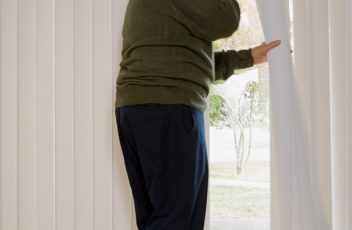 Elderly man on phone and looking out of window